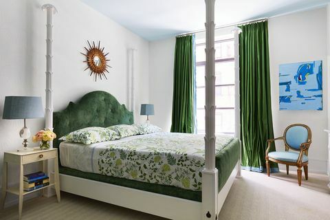 ห้องนอนสีขาวพร้อมเตียงสี่เสาและผ้าม่านสีเขียว