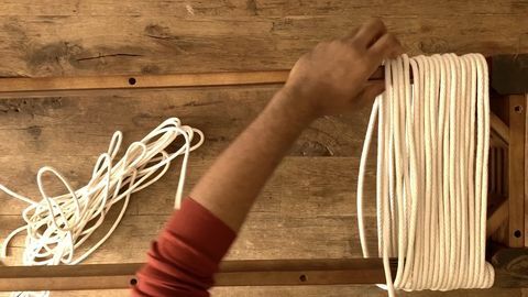 mano envolviendo la cuerda alrededor de la madera