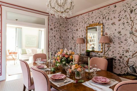 भोजन कक्ष, गुलाबी पुष्प वॉलपेपर, गुलाबी मखमली खाने की कुर्सियों के साथ अंडाकार लकड़ी की मेज, पुष्प आलिंगन