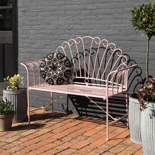 Довольно розовая металлическая садовая скамейка