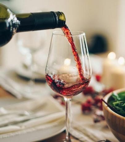 მაგიდასთან ჭიქაში ასხამენ წითელ ღვინოს