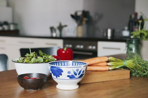 Warzywa i miski na drewnianym stole w kuchni