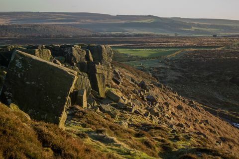 Landschaftsansicht einschließlich einer Felswand am Rand der Bordsteinkante im Peak District, Großbritannien