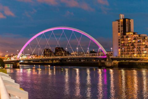 UK, Škotska, Glasgow, Osvijetljeni most Clyde Arch preko rijeke Clyde u sumrak