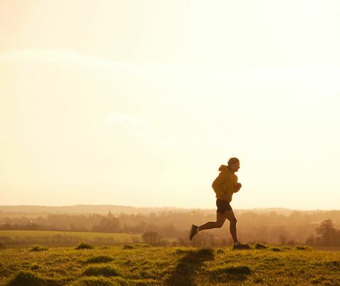 bėgikas bėgioja ant kalvos saulėlydžio metu
