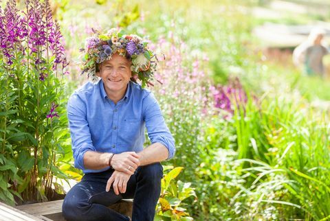 Chris Bartscha trägt eine florale Kopfkrone, die den Gartentag unterstützt