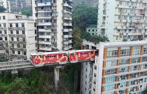 Stadtbahn fährt durch Wohngebäude in Chongqing