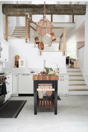 кухня, белая плитка с белыми кухонными столешницами и шкафами, остров с деревянной столешницей из блока мясника