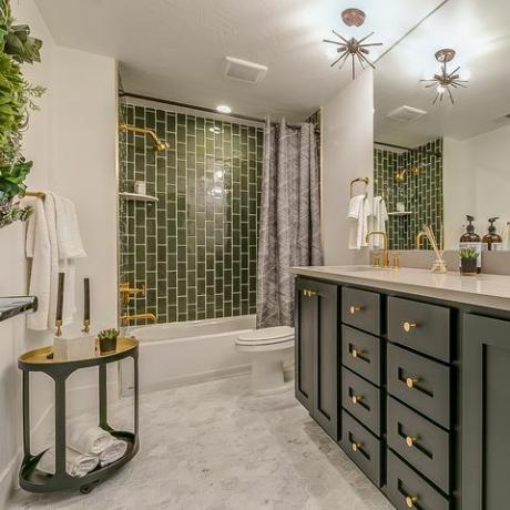 Grün ist das Thema in diesem schönen Badezimmer mit Messingarmaturen und Armaturen