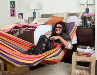 Rachel Roy sur son lit rayé dans sa chambre avec un hamac