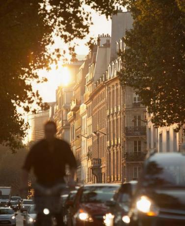 Rušná ranná dochádzka prechádza za úsvitu vo francúzskom Paríži za kultovou haussmannovskou architektúrou