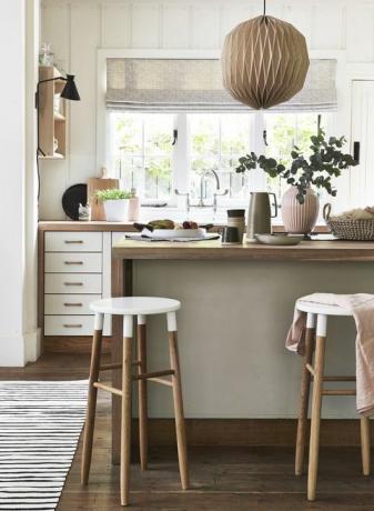 lagom, švédská myšlenka mít správné množství, je zachycena v dokonalé rovnováze neutrálních odstínů růžových odstínů, dřeva a útulných textur a dřevěná kuchyně s kuchyňskou deskou, bíle natřené desky tabulek a čela zásuvek dodávají tomuto elegantnímu schématu dřevěného přívěsku dostatečný kontrast světlo