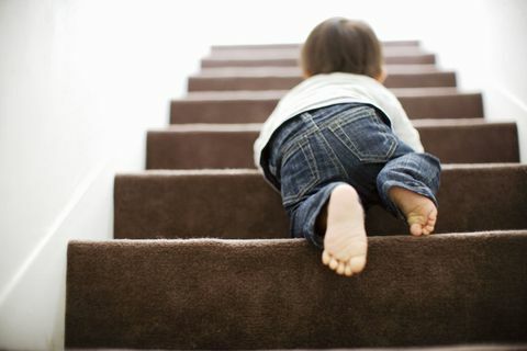 Baby steigt krabbelnd die Treppe hinauf
