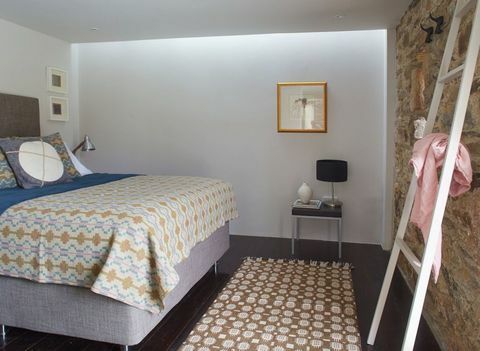 काउंटी किलकेनी में इनिस्टिओग गांव के पास एक परिवर्तित दो बेडरूम का पत्थर का खलिहान। नीचे का बेडरूम: पीली दीवारों और फर्नीचर के विपरीत लकड़ी के फर्श को गहरे रंग से रंगा गया है
