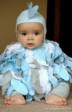 dojenček oblečen kot piščanec z modrim, belim in sivim perjem iz filca