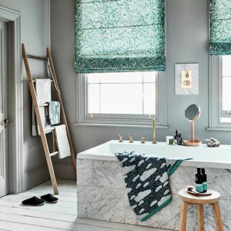 zaļās tēmas vannas istaba ar gaiši pelēkām sienām