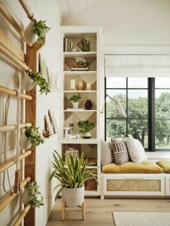 窓際の座席、ホームオフィスとホームジム、屋内植物、白い収納キャビネット