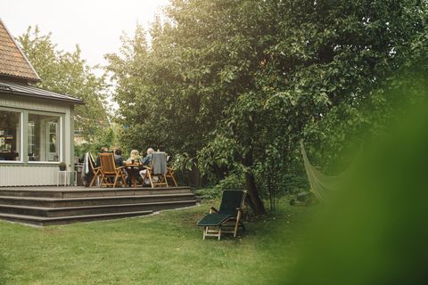 senior mannen en vrouwen genieten van diner terwijl ze aan de eettafel zitten tijdens een tuinfeest