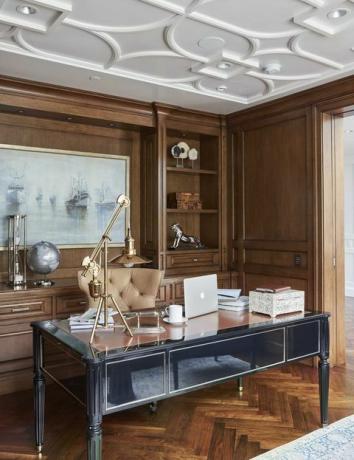 kancelář s černým kancelářským stolem, dřevěná podlaha, dřevěné skříně