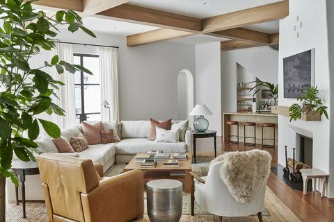 vardagsrum, vita väggar, träbjälkar, vit soffa, brun läderstol