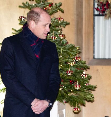 sang ratu menghiasi pohon natal luar ruangannya dengan mahkota merah mini
