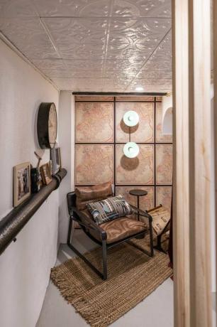 ruda odinė kėdė su rudu mažu kilimėliu, žemėlapiai ant sienos, sienelės, sieninis laikrodis