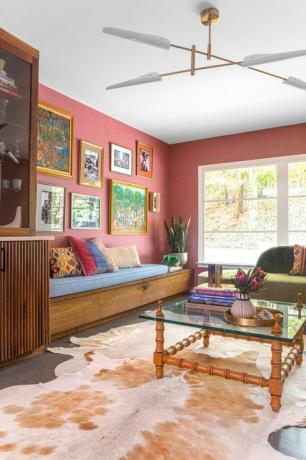 svetainė, raudona sienų danga, žalia sofa, suoliuko sėdynė, galerijos sienų menas,