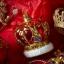 Краљица украшава божићно дрвце на отвореном мини црвеним крунама