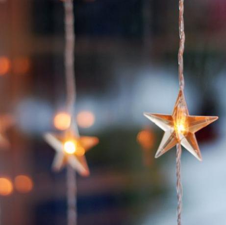 luminile de Crăciun în formă de stea într-o fereastră