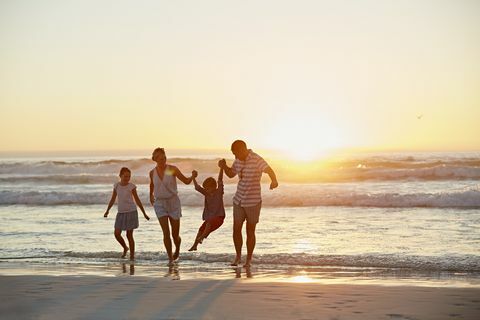 Szülők gyermekekkel élvezik a nyaralást a tengerparton