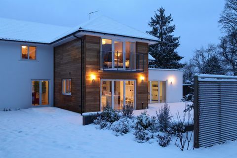 Casa de família iluminada na neve