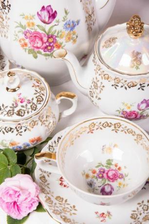 ערכת תה פרחונית עתיקה על מפה לבנה