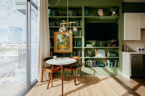 Estantería verde para almacenamiento en la sala de estar de planta abierta de la casa de Nashville Airbnb Plus