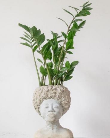 yeux studios ragazza fatta a mano con un vaso per piante in cemento afro
