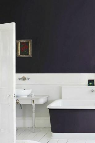 暗い色の壁と浴槽のあるバスルーム