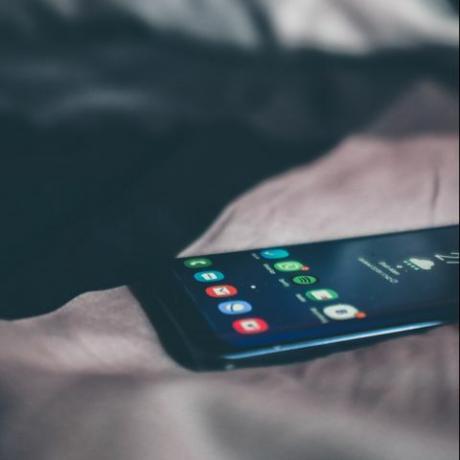 hoge hoekmening van mobiele telefoon op bed