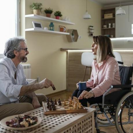 Mann und Frau im Rollstuhl spielen Schach