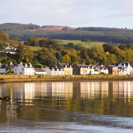hus vid havet som återspeglas i lugna vatten i lamlash bay, Isle of Arran