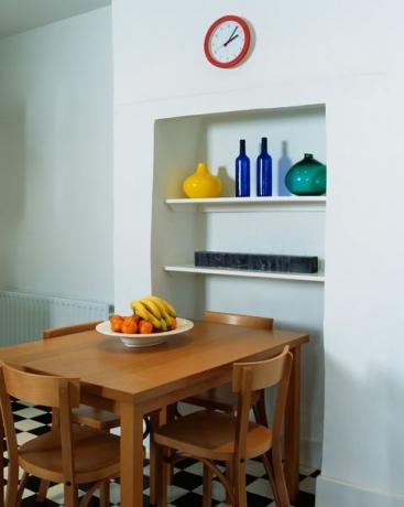 идеи ниши, простой деревянный стол и стулья в современной белой кухне с черно-белым полом из шахматной доски