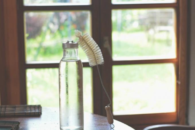 Bezodpadový kartáč na tyč na čištění lahví a skleněných lahví s vodou v kuchyni