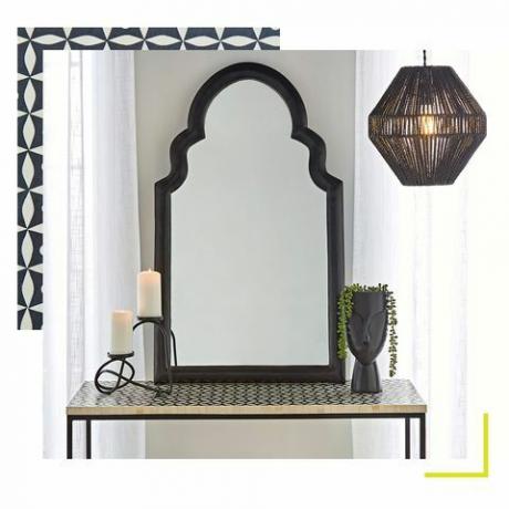 ogledalo, ki sedi na vzorčni omari, poleg lončka in sveče