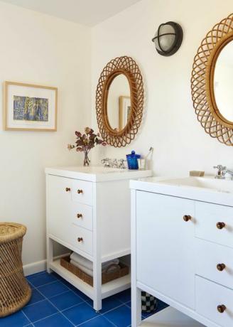 白いキャビネットと洗面器、籐の鏡と青いタイル