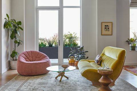 vardagsrum med rosa stol och gul soffa