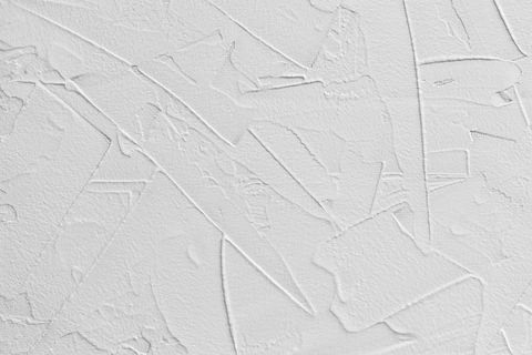 weißer abstrakter Hintergrund aus Pastenfüller und Klebeputz mit unregelmäßigen Strichen und Strichen