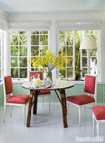 todd romano florida mājas ēdamistaba ar sarkaniem krēsliem un rotangpalmas galdu