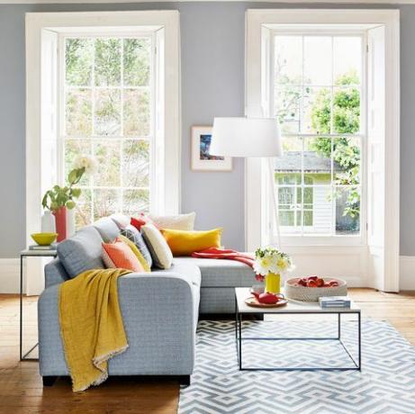 ספה אפורה וקירות אפורים בהירים בסלון