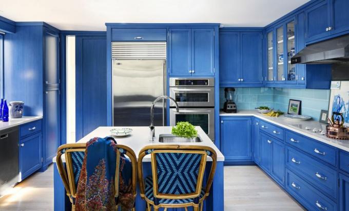 Kobaltblaue Küche mit geflochtenen Barhockern