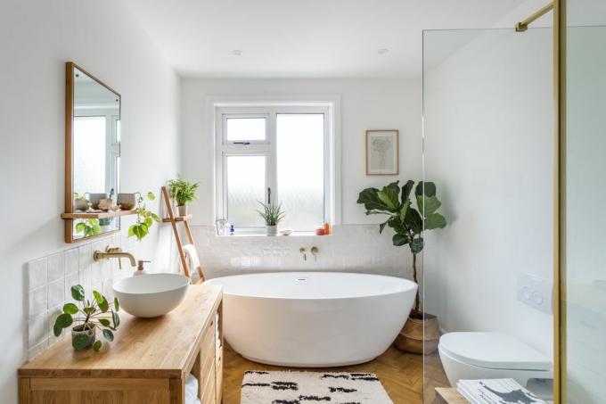 Badezimmer weiß mit Zimmerpflanzen, Badewanne und Holz