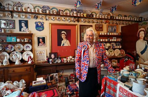 karaliskā superfane Margareta Tailere savā jubilejas istabā pozē fotogrāfijai ar savu karalisko piemiņlietu kolekciju