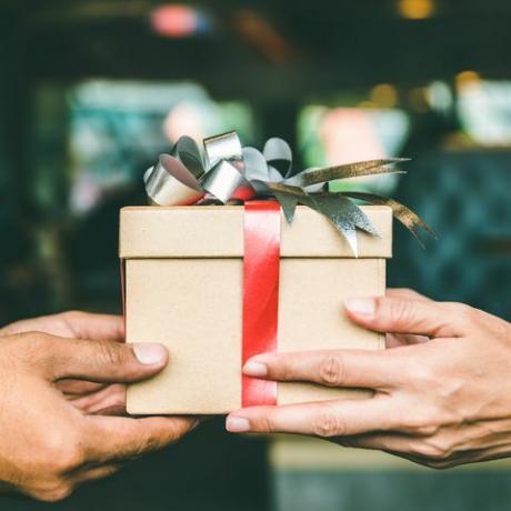 Обрезанная рука мужчины дарит рождественский подарок подруге